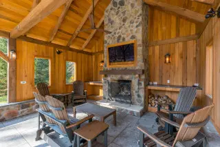 Stone fireplace with adirondack seating and sliders, all within the stunning wooden gazebo 