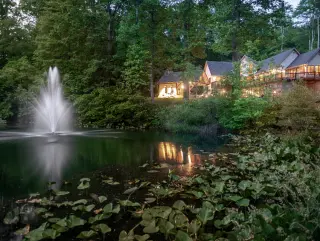 Scenic lake with fountain, cabin in background