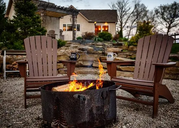 Cabin exterior, fire pit and adirondak chairs in foreground