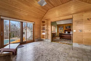 Large wet-room shower, sliding glass doors to the side lead to private hot tub, open doors show to king sleighbed.