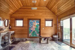 Open wet-room shower with stained glass inlay on the back wall, sliging glass doors to the side and his/her sinks.