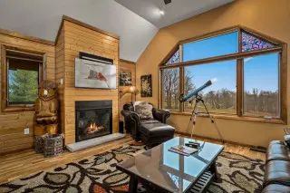 Living room with fireplace, large windows and telescope