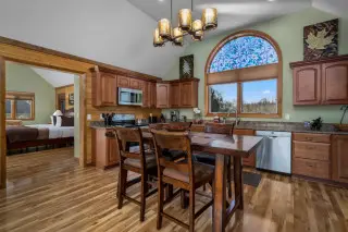 Dining table with kitchen in the background. Stained glass on the back window. 