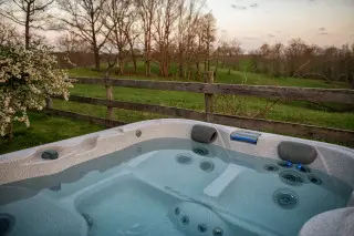 Crystal Clear water in the private, secluded hot tub, with rolling hills and fields in the background. 