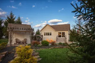 Cabin exterior, with green grass and landscapes stepping stones