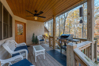 Porch with seating coffee table, gas grill. 