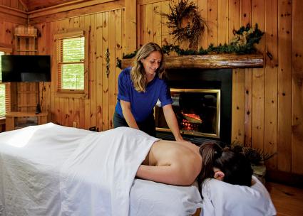 Woman laying on massage table, massage therapist  administering massage