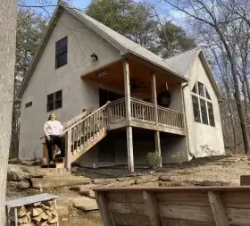 Woman stands on the steps of our Oak Ridge cabin