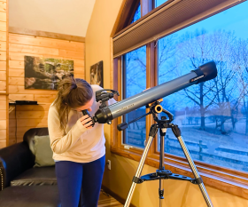 Woman looking through a telescope