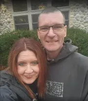 Jen Review Man and woman smiling in front of cabin