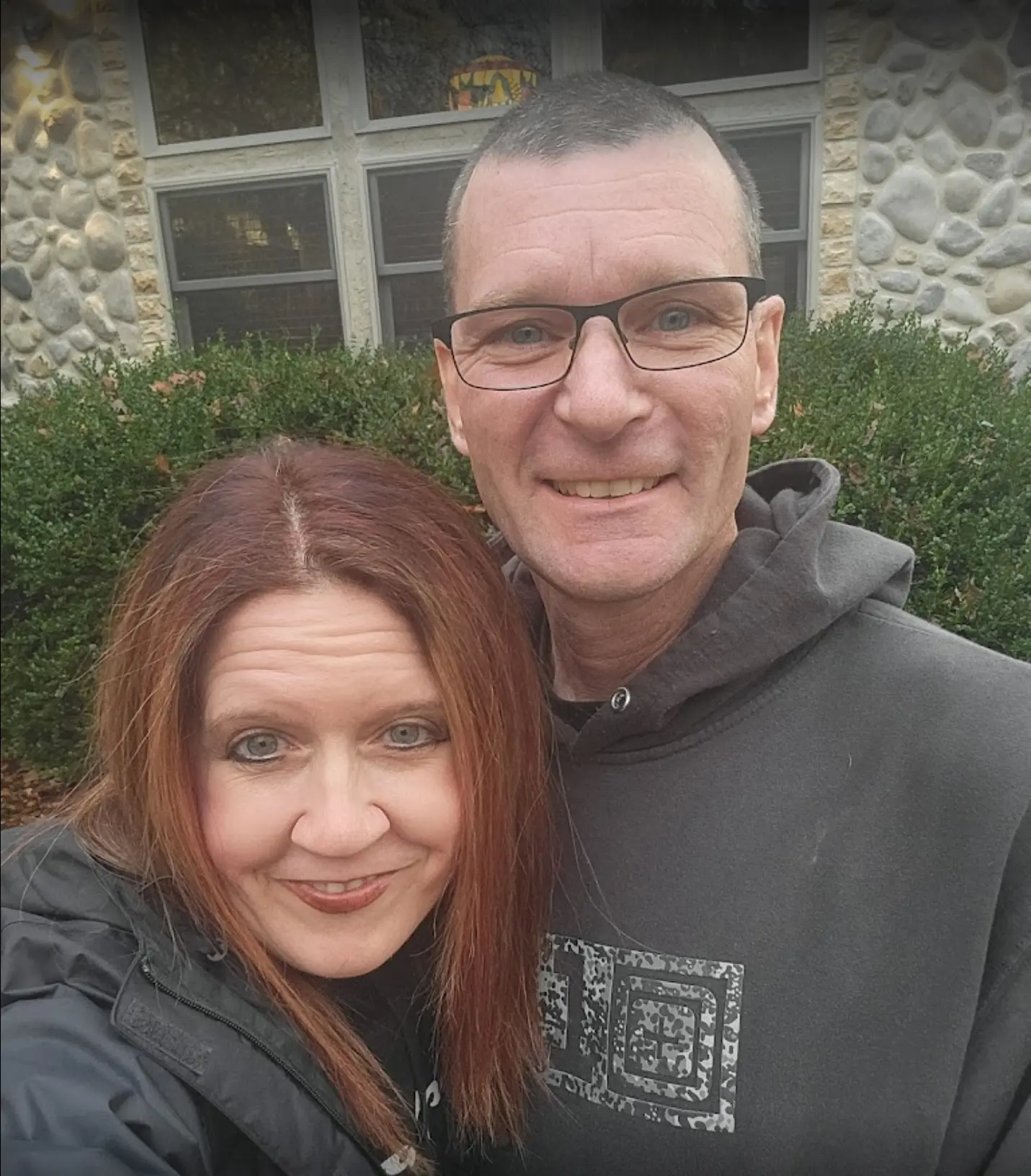 Man and woman smiling in front of cabin