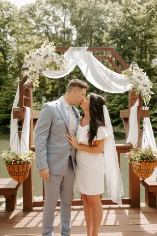 Bride and Groom sharing a kiss in front of a decorated archway