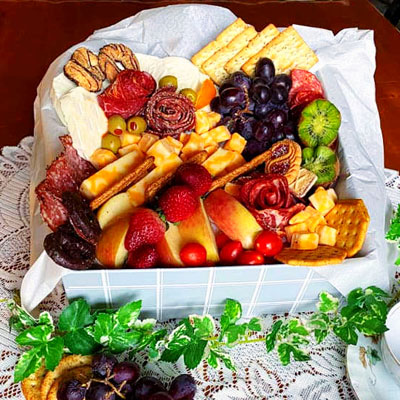 Photo of a medium sized Charcuterie box with meats, fruit, crackers and cheese