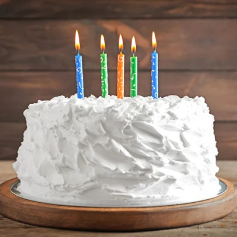 Photo of a white cake with 5 colorful candles