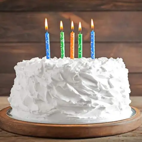 Photo of a white cake with 5 colorful candles