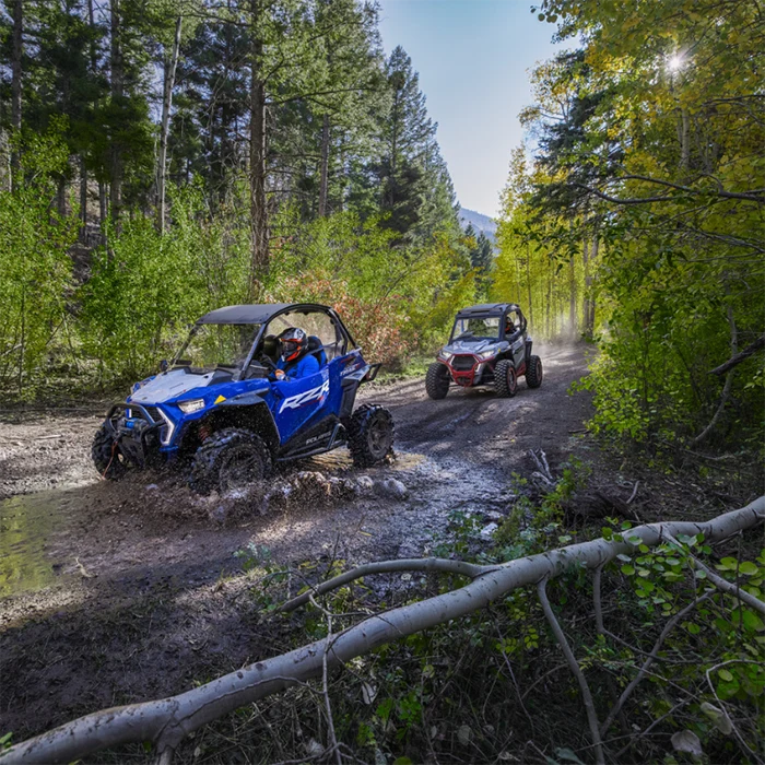 UTVs driving on a muddy off road trail