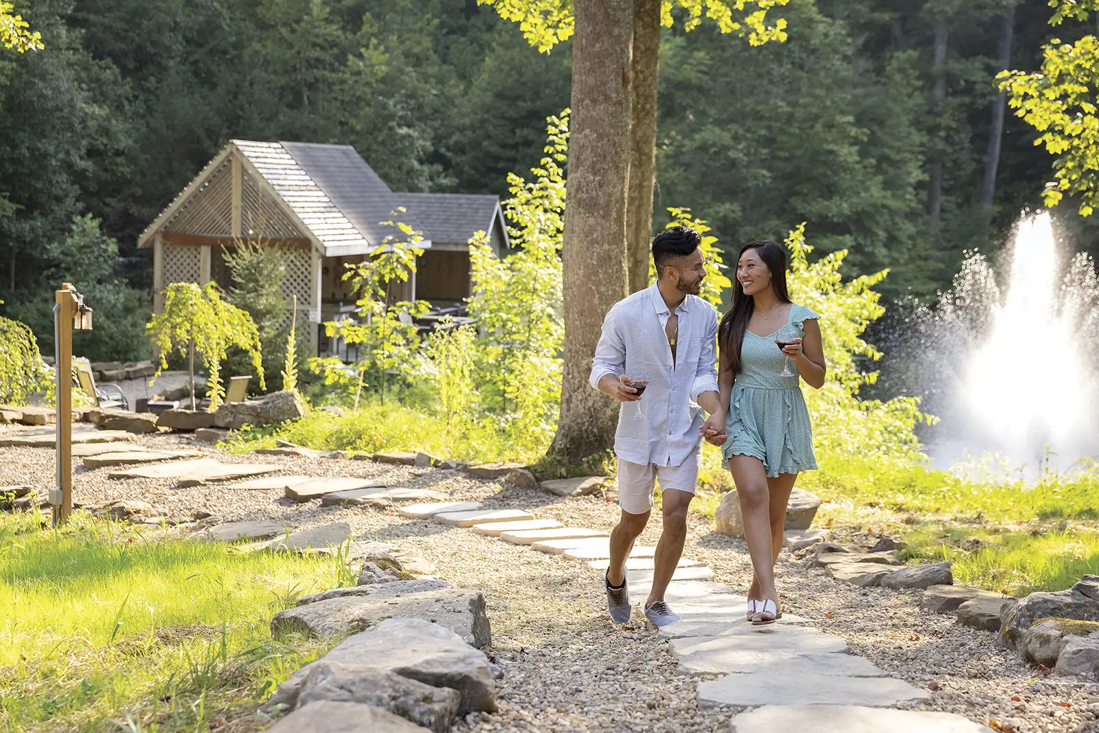 Couple walking with wine beside a private pond and fountain at Cherry Ridge Retreat