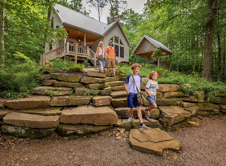 Family walking down stone steps Family walking down natural stone steps outside a secluded woodland cabin with a covered gazebo