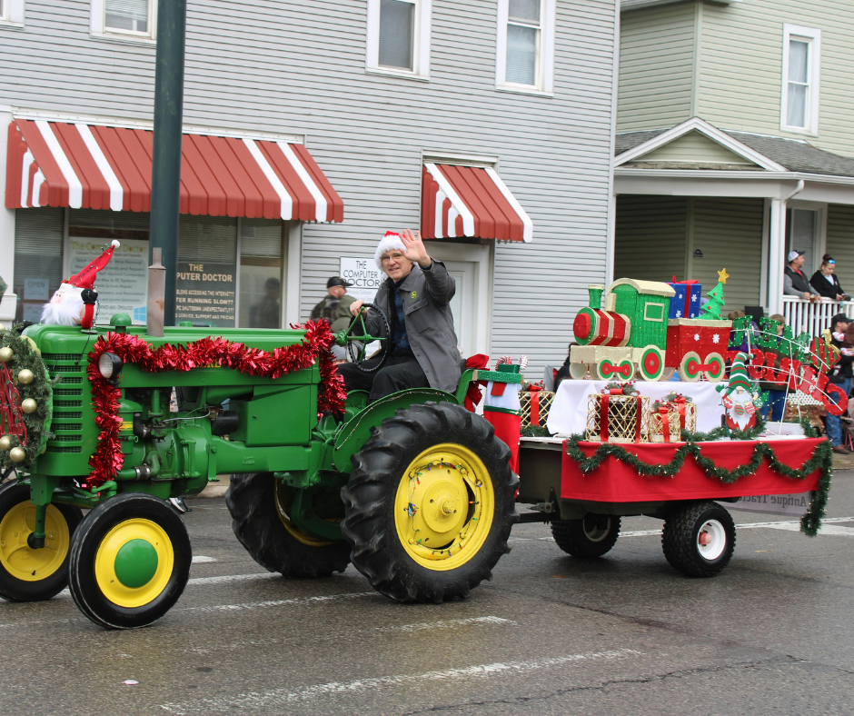Christmas decorated tractor pulling a parade float. 