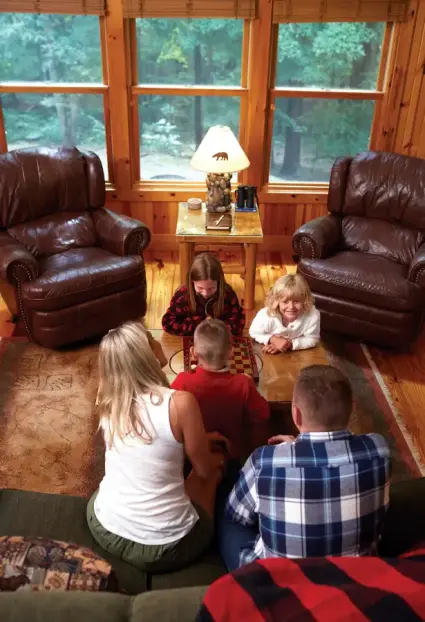Family playing a board game together inside a cozy Hocking Hills cabin