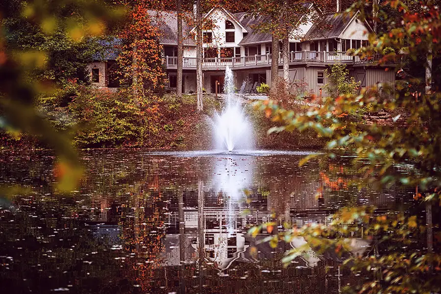 Large Hocking Hills cabin overlooking a private pond with fountain and colorful fall foliage