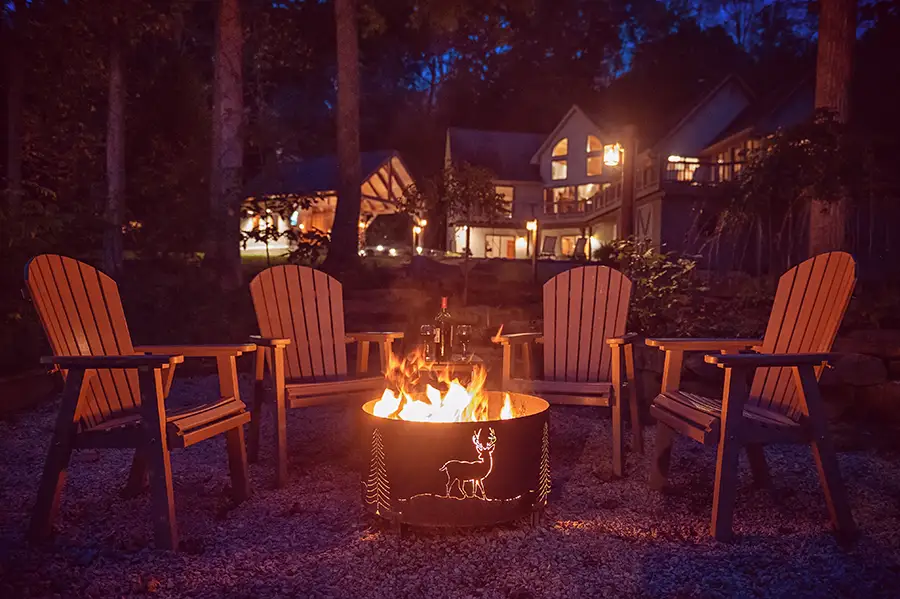 Outdoor fire pit with Adirondack chairs beside a secluded Hocking Hills cabin at night