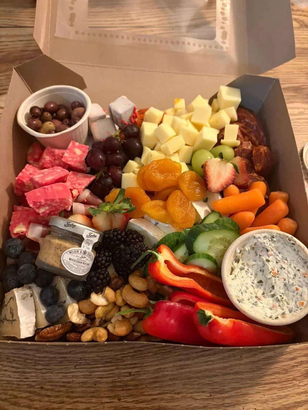 charcuterie box of fruit, vegetables, cheeses, meats and dips