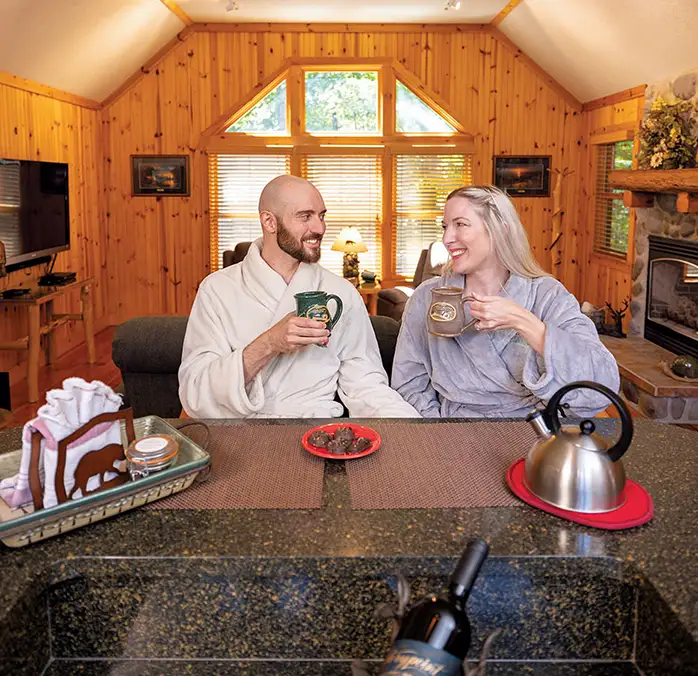 Couple Enjoying Coffee in a Cozy Cabin Couple enjoying coffee together in a cozy wood-paneled cabin kitchen.