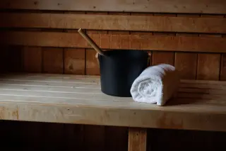 Sauna bucket and towel, sitting on sauna bench