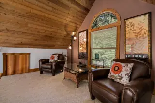 2 leather chairs with decorative pillows, coffee table between them. 