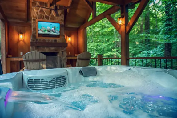 Bubbling hot tub, with fireplace and tv in background