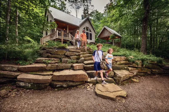 A family coming down the stone steps at Still waters cabin situated in secluded woods
