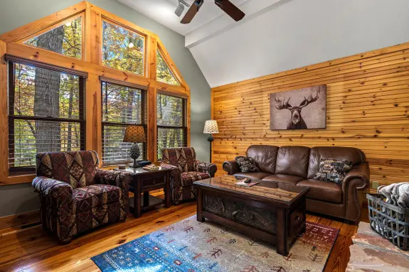 Living room with large windows, seating and leather couch