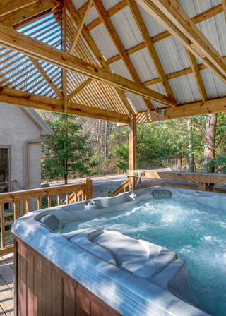 clean bubbling hot tub under private gazebo, cabin in background
