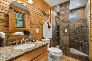 bathroom with 2 person shower, toilet and sink. 