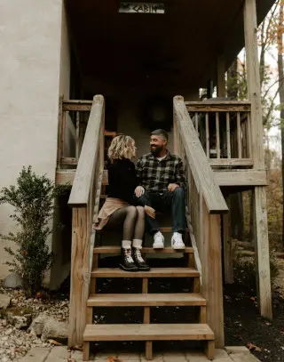 Man and woman sitting on steps outside leading to the cabin