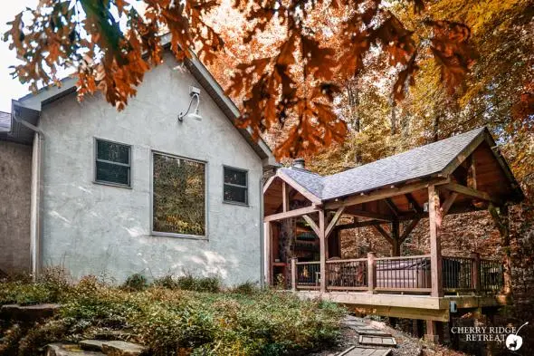 Cabin with stone exterior, spring flowers blooming in front of the cabin