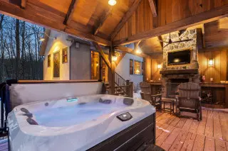 covered gazebo with hot tub, fireplace, tv and gliding chairs. 