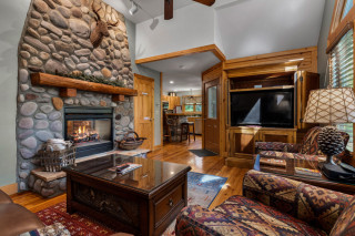 Living room with stone fireplace, coffee table and Smart TV