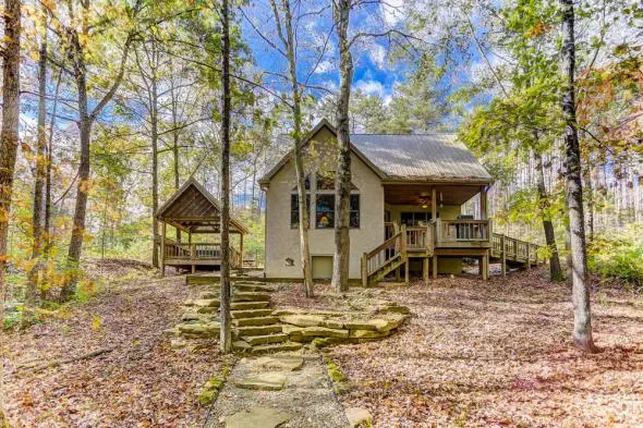 Cabin with stone walkway, woods surrounding